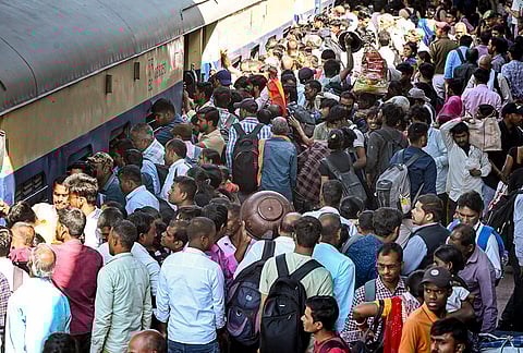 Passengers rush to board a train at Patna Railway Station ahead of the 'Holi' festival.