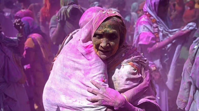 A woman covered in pink powder during the Widow Holi celebration at Gopinath Temple.