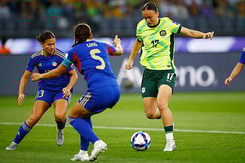 Australia's Amy Sayer, right, competes for the ball with Philippines' Hali Long and Angela Beard, left, during the Women's Asia Cup soccer match between Australia and the Philippines in Perth, Australia.