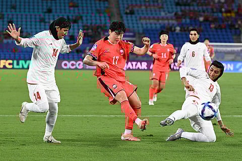 South Korea's Choi Woo-jung, centre, takes a shot on goal as Iran's Fatemeh Makhdoomi, left, and Fatemeh Amineh attempt to block during the Women's Asia Cup soccer match between Iran and South Korea on the Gold Coast, Australia.