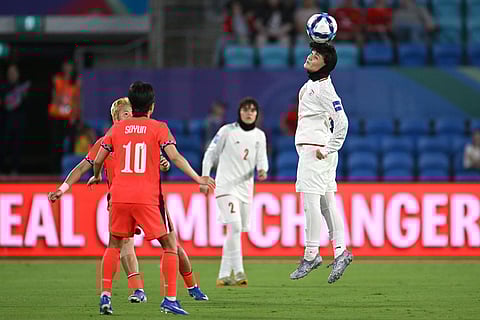 Iran's Fatemeh Pasandideh heads the ball as South Korea's Ji So-yun, left, looks on during the Women's Asia Cup soccer match between Iran and South Korea on the Gold Coast, Australia.