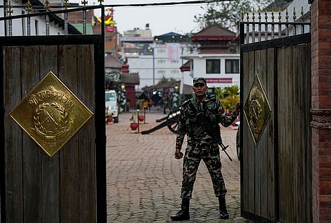 A security person stands guard at a polling station ahead of the parliamentary elections, in Kathmandu.