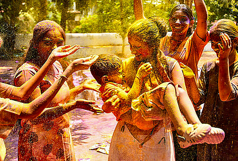 People smeared in 'gulal' during celebrations for the 'Holi' festival, in Kozhikode, Kerala.