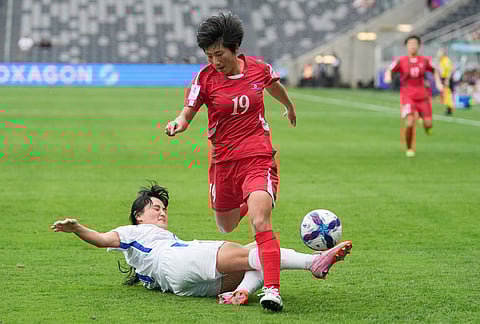 Uzbekistan's Maftuna Shoyimova tackles North Korea's Sin Hyang during the Women's Asia Cup soccer match between North Korea and Uzbekistan in Sydney.