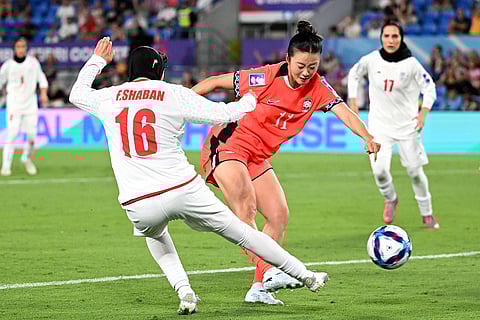 South Korea's Choe Yu-ri kicks the ball past Iran's Fatemeh Shaban, left, to score her team's first goal during the Women's Asia Cup soccer match between Iran and South Korea on the Gold Coast, Australia.