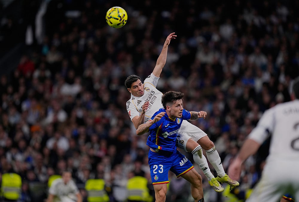 Getafe's Adrian Liso jumps for the ball against Real Madrid's Brahim Diaz during a Spanish La Liga soccer match between Real Madrid and Getafe in Madrid, Spain. - | Photo: AP/Manu Fernandez