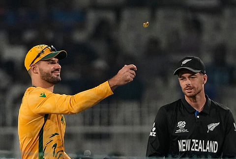 South Africa's captain Aiden Markram tosses the coin for toss as New Zealand's captain Mitchel Santner watches at the start of the first T20 World Cup cricket semifinal match between New Zealand and South Africa in Kolkata.