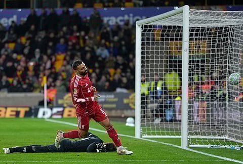 Liverpool's Mohamed Salah scores his side's opening goal during the English Premier League soccer match between Wolverhampton Wanderers and Liverpool in Wolverhampton, England.
