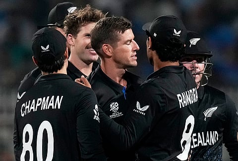 New Zealand's Cole McConchie, center, celebrates with teammates the wicket of South Africa's Quinton de Kock during the first T20 World Cup cricket semifinal match between New Zealand and South Africa in Kolkata.