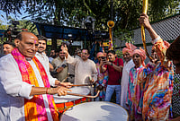 Day In Pics: March 04, 2026 | Photo: PTI/Kamal Kishore : Union Defence Minister Rajnath Singh plays a traditional instrument with others during the Holi festival celebration at his residence, in New Delhi.