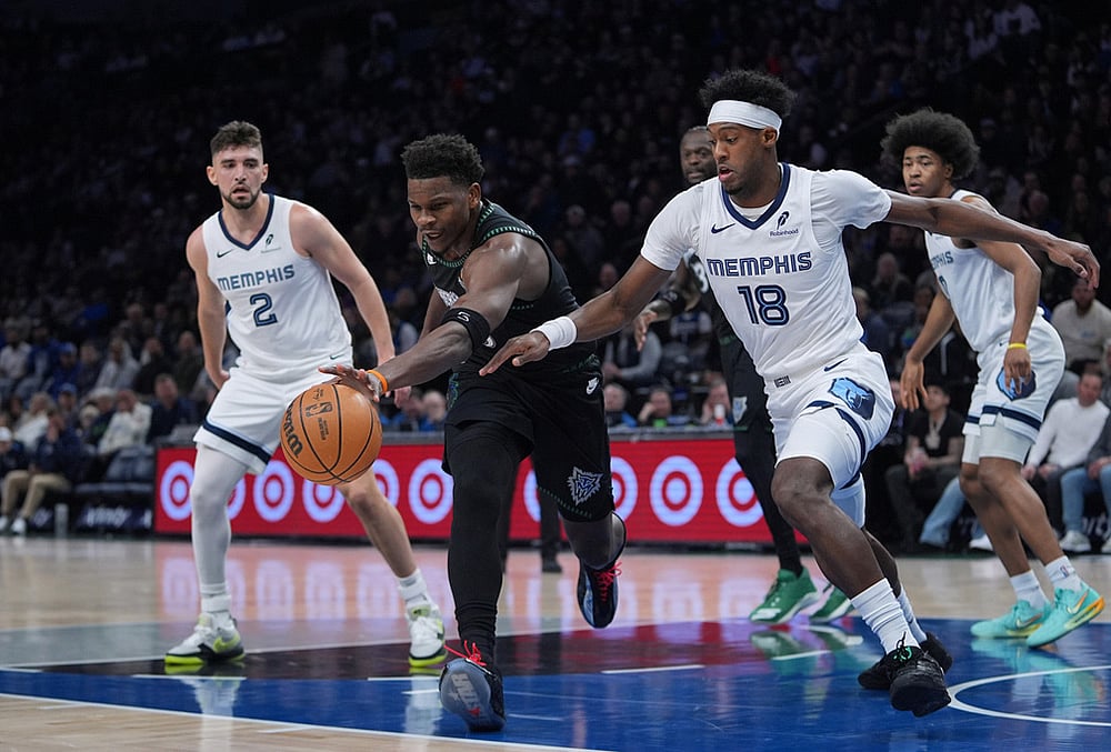 Minnesota Timberwolves guard Anthony Edwards, middle, reaches for the ball against Memphis Grizzlies forward Olivier-Maxence Prosper (18) during the first half of an NBA basketball game in Minneapolis.  - | Photo: AP/Abbie Parr