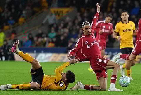 Liverpool's Hugo Ekitike, right, is pulled back by Wolverhampton Wanderers' Santiago Bueno during the English Premier League soccer match between Wolverhampton Wanderers and Liverpool in Wolverhampton, England.