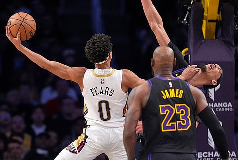 New Orleans Pelicans guard Jeremiah Fears, left, shoots as Los Angeles Lakers center Jaxson Hayes, right, defends and forward LeBron James watches during the second half of an NBA basketball game in Los Angeles.