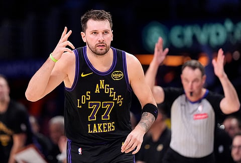 Los Angeles Lakers guard Luka Doncic, left, gestures after scoring during the first half of an NBA basketball game against the New Orleans Pelicans, in Los Angeles.