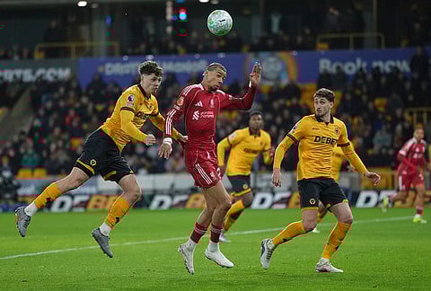 Liverpool's Hugo Ekitike, center, is challenged by Wolverhampton Wanderers' Ladislav Krejcí, left, during the English Premier League soccer match between Wolverhampton Wanderers and Liverpool in Wolverhampton, England.