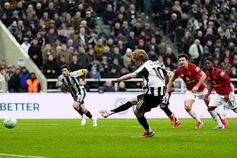 Newcastle United's Anthony Gordon scores from the penalty spot during an English Premier League soccer match against Manchester United in Newcastle, England.