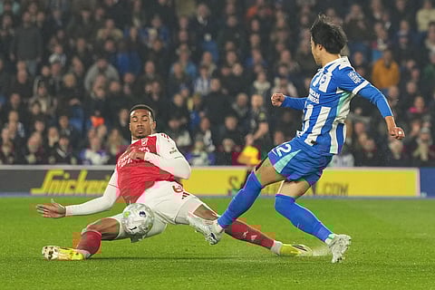 Arsenal's Gabriel blocks Brighton's Kaoru Mitoma during the Premier League soccer match between Brighton and Arsenal in Brighton, England.