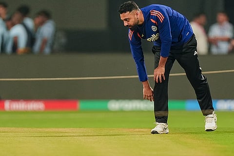 India's Varun Chakaravarthy inspects the pitch during a training session ahead of the ICC Men's T20 World Cup 2026 semi-final cricket match between India and England, in Mumbai.