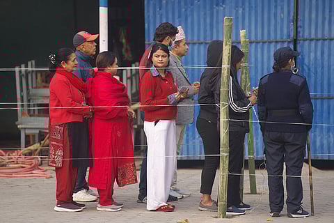 People wait in a queue to cast their votes for the parliamentary election in Kathmandu, Nepal.