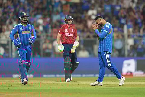 India's Varun Chakravarthy, right, celebrates the dismissal of England's Jos Buttler, center, during the T20 World Cup cricket semi-final match between India and England in Mumbai, India.
