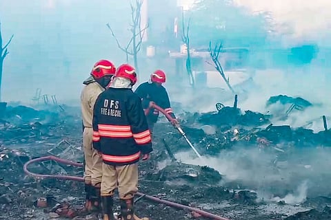 Firefighters at the site after a massive fire broke out in a cluster of shanties, gutting more than 50 huts, in the Rithala area, New Delhi.