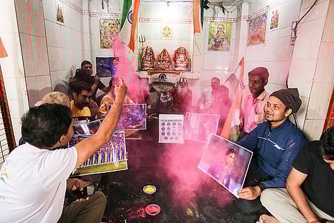 People hold portraits of Indian cricketers in support of the country’s win ahead of the ICC Men's T20 World Cup 2026 semifinal cricket match against England, in Prayagraj.