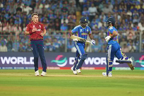 England's Sam Curran, left, reacts as India's Sanju Samson, center, and batting partner Ishan Kishan run between the wickets to score during the T20 World Cup cricket semi-final match between India and England in Mumbai, India.