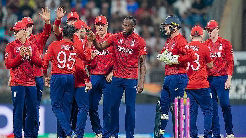 England's Adil Rashid celebrates with teammates after a DRS review for the wicket of West Indies' Roston Chase during an ICC Men's T20 World Cup 2026 cricket match between England and West Indies, at the Wankhede Stadium, in Mumbai, Maharashtra. - | Photo: PTI/Kunal Patil