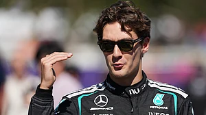 AP/Heath McKinley : Mercedes driver George Russell of Britain gestures as he walks down the F1 Paddock ahead of the Australian Formula One Grand Prix at Albert Park, in Melbourne, Australia.