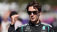 AP/Heath McKinley : Mercedes driver George Russell of Britain gestures as he walks down the F1 Paddock ahead of the Australian Formula One Grand Prix at Albert Park, in Melbourne, Australia.