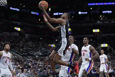 San Antonio Spurs guard De'aaron Fox (4) drives to the basket against the Detroit Pistons during the second half of an NBA basketball game in San Antonio.
