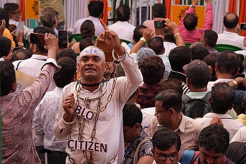 A agitator wears shackles during a sit-in by West Bengal Chief Minister Mamata Banerjee, unseen, to protest against the alleged arbitrary deletions from the post-SIR electoral rolls, in Kolkata.