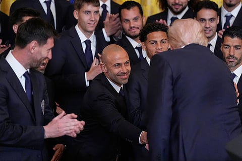 President Donald Trump shakes hands with head coach Javier Mascherano as he speaks at an event to honor the 2025 Major League Soccer champions Inter Miami CF in the East Room of the White House in Washington. Lionel Messi watches at left.