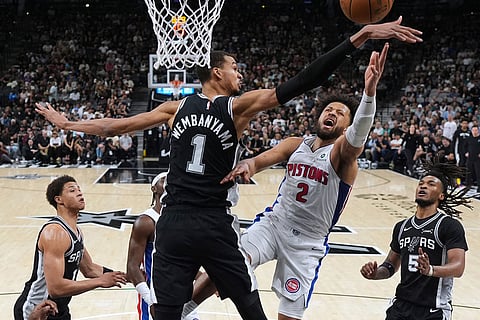 Detroit Pistons guard Cade Cunningham (2) drives to the basket against San Antonio Spurs forward Victor Wembanyama (1) during the first half of an NBA basketball game in San Antonio.