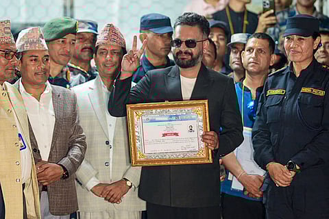 Balendra Shah, a candidate of the Rastriya Swatantra Party (RSP) from Jhapa Constituency-5, shows a certificate at the Election Commission premises after winning the constituency in the Nepal general elections, in Jhapa, Nepal. Balendra Shah 'Balen' defeated four-time prime minister K P Sharma Oli by a huge margin of about 50,000 votes. 