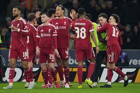 Liverpool's Curtis Jones, right, celebrates with teammates after scoring during the English FA Cup soccer match between Wolves and Liverpool in Wolverhampton, England.