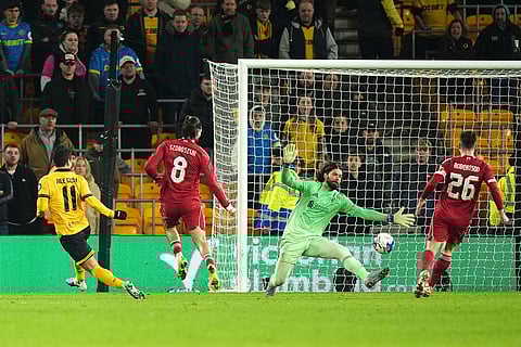 Wolverhampton Wanderers' Hwang Hee-Chan, left, scores their first goal of the game during an English FA Cup fifth round match against Liverpool in Wolverhampton, England. 