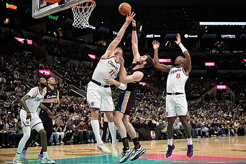 San Antonio Spurs center Luke Kornet and Los Angeles Clippers center Brook Lopez (11) fight for possession during the first half of an NBA basketball game in San Antonio.