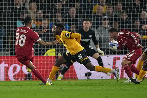 Liverpool's Ryan Gravenberch, left, shots on goal during the English FA Cup soccer match between Wolves and Liverpool in Wolverhampton, England.