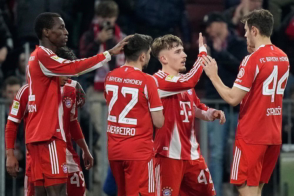 Bayern's Nicolas Jackson, left, celebrates with team mates Raphael Guerreiro (22), Lennart Karl (42) and Josip Stanisic (44) after scoring his side's fourth goal during the Bundesliga soccer match between FC Bayern Munich and Borussia Moenchengladbach in Munich, Germany. - | Photo: AP/Matthias Schrader