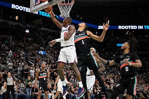 Los Angeles Clippers guard Kris Dunn (8) goes to the basket against San Antonio Spurs center Victor Wembanyama (1) during the second half of an NBA basketball game in San Antonio.
