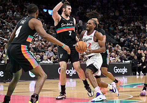 Los Angeles Clippers forward Kawhi Leonard (2) drives against San Antonio Spurs center Luke Kornet (7) and guard De'Aaron Fox, left, during the first half of an NBA basketball game in San Antonio.