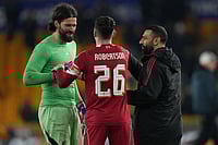 | Photo: AP/Dave Shopland : Liverpool's goalkeeper Alisson, left Liverpool's Andrew Robertson, center, and Liverpool's Mohamed Salah celebrate at the end of the English FA Cup soccer match between Wolves and Liverpool in Wolverhampton, England.