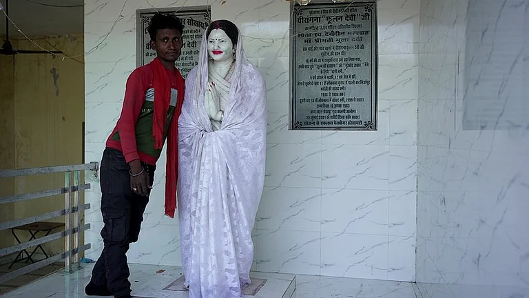 Anmol, a local villager takes us to the house of Phoolan Devi in Shekhpur Guda. As he unveils the Statue from its “ghoongat”, he stops to pose with it for the camera - | Photo: Animikh Chakrabarty/Outlook