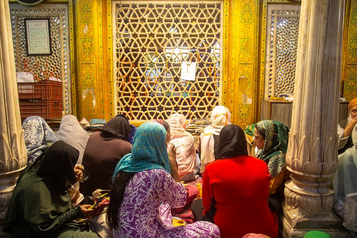 A group of women seated near the wall surrounding the mazar of Khwaja Nizamuddin Auliya 