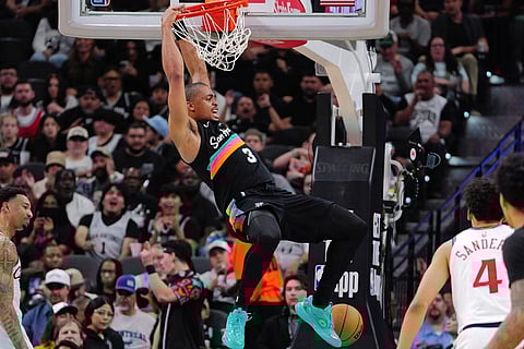 San Antonio Spurs forward Keldon Johnson, center, dunks during the first half of an NBA basketball game against the Los Angeles Clippers in San Antonio.