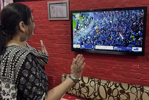 A woman cheers as she watches a live telecast of T20 World Cup cricket final match between India and New Zealand, in Lucknow Uttar Pradesh.