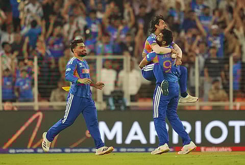 India's Jasprit Bumrah celebrates the wicket of New Zealand's Rachin Ravindra with teammate India's Ishan Kishan during the T20 World Cup cricket final match between India and New Zealand in Ahmedabad.