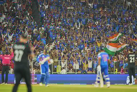 Indian cricket fans cheer as India's Sanju Samson hits a six during the T20 World Cup cricket final match between India and New Zealand in Ahmedabad.