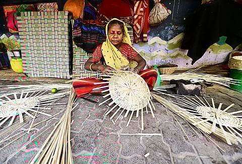 A woman prepares a bamboo basket on the occasion of International Women's Day, in Prayagraj, Uttar Pradesh.